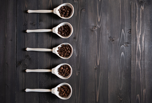Coffee beans from thick places, different varieties of roasted coffee in wooden spoons