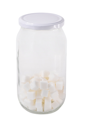 Sugar cubes in a glass jar isolated on the white background with clipping path
