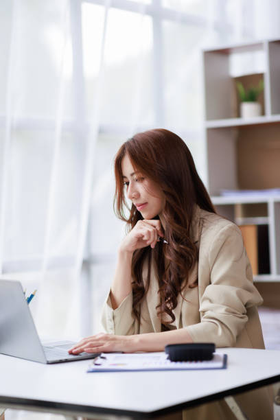 Asian businesswoman working on laptop computer and graph planning a strategy in modern office, Asian woman doing analyzing the financial report, business plan investment, finance analysis concept Asian businesswoman working on laptop computer and graph planning a strategy in modern office, Asian woman doing analyzing the financial report, business plan investment, finance analysis concept financial advisor virtual stock pictures, royalty-free photos & images