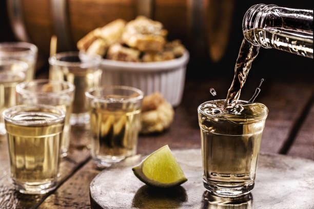 glass of Cachaça, pinga, cana or caninha is the sugar cane brandy, typical drink from Brazil, drops of drink flying, spilling or overflowing, filling the glass stock photo