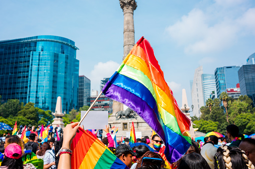 Mexico City, Mexico; June 25 2022: Hand holding pride flag, lgbt, running.