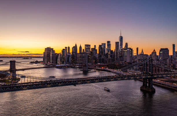 istock Large cable stayed bridges spanning East River. Skyline with downtown skyscrapers against romantic colourful sunset sky. Manhattan, New York City, USA 1405848329