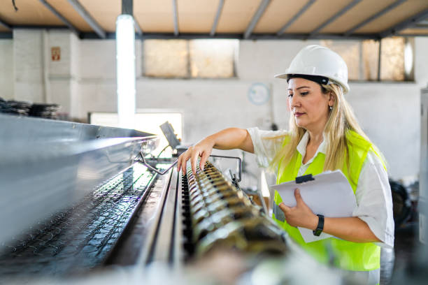 une ingénieure effectue le contrôle qualité dans une usine - inspector safety construction reflective clothing photos et images de collection