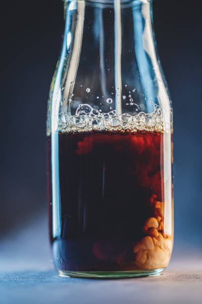 Pour Coffee And Milk Into A Glass Bottle