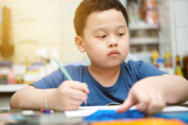 istock Boy is writing book at home 1405850461