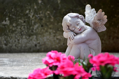 Guardian angel sleeping on concrete background