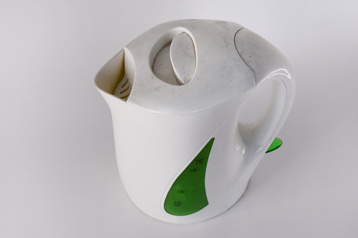 Old and obsolete electric kettle on the white background