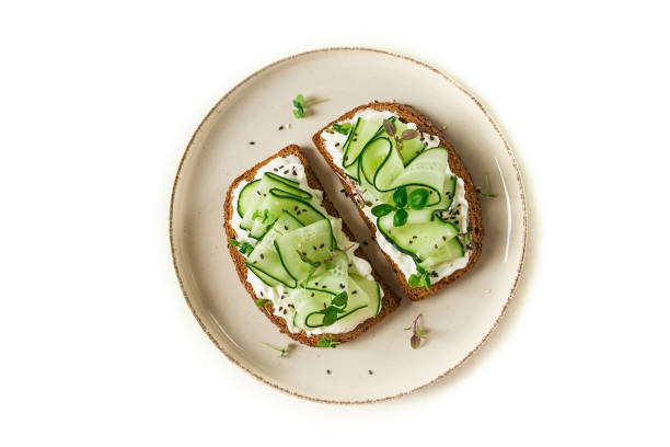istock Breakfast, cereal bread sandwiches, cream cheese, sliced cucumber, with micro greenery on a light table, close-up, top view, selective focus, no people, 1405853823
