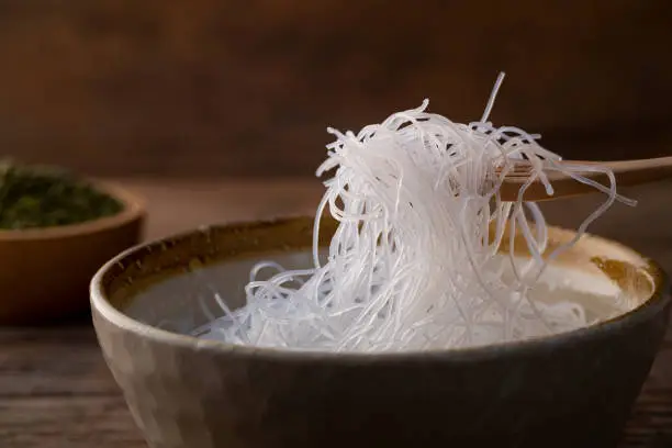 Close up Fresh Glass Noodle (Transparent bean vermicelli) on wooden fork in a bowl