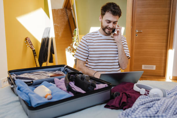 istock Young man using online travel services and preparing for a trip 1405857875