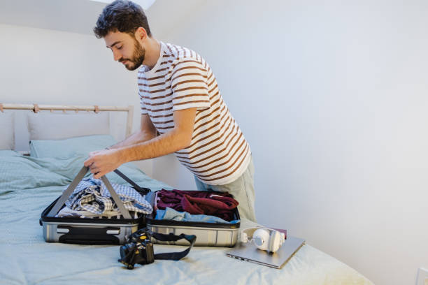 istock Young man finishing packing for a vacation 1405857984