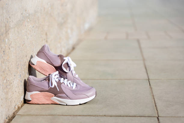 istock sneakers stand on paving stones. Place for text 1405859531