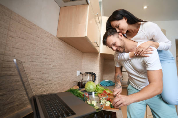 istock Tender wife hanging on man neck during cooking in kitchen 1405862091