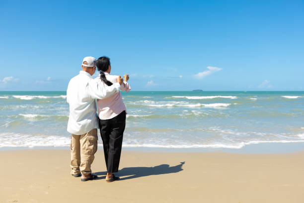 istock back view romantic senior couple looking sea and sky on the beach 1405862310