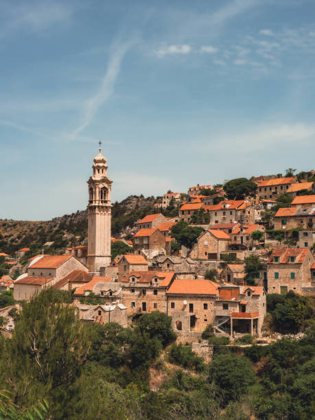 blick auf altstadt, turm und häuser in ložišća, insel brac kroatien - croatian culture stock-fotos und bilder