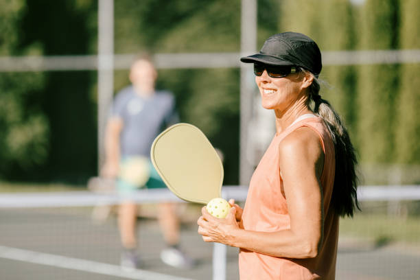 Mature Woman Playing Pickleball Game On Summer Morning stock photo