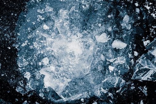 Ice, crushed on black background. Pieces of crushed ice and snow spread away. The explosion of ice.