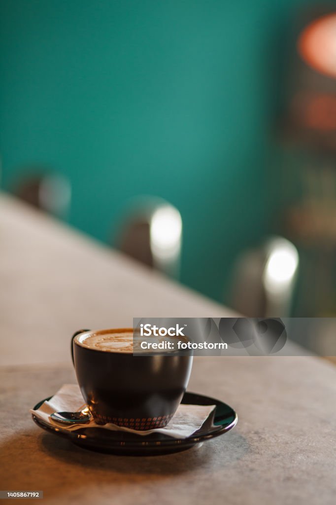 Cup of delicious cappuccino coffee with latte art served on a bar counter Close up shot of a cup of delicious cappuccino coffee with latte art served on a bar counter at the coffee shop. Coffee - Drink Stock Photo