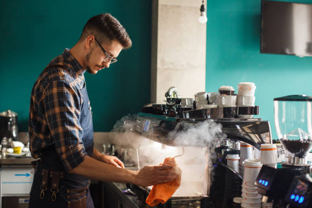 istock Barista using a steamer on espresso machine when preparing customer's orders 1405867293