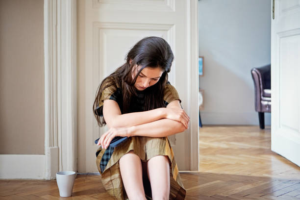 istock Depressed young woman standing sad at home 1405871097