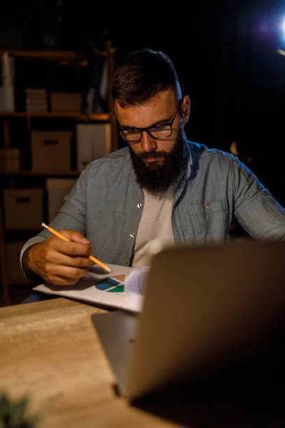 istock Businessman staying late at the office, analyzing a chart for a project he is working on 1405871273