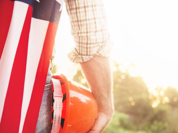 istock Attractive man in work clothes, holding American Flag 1405872334