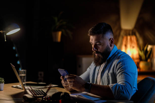 istock Businessman checking text messages on his smart phone while working at his desk 1405872719