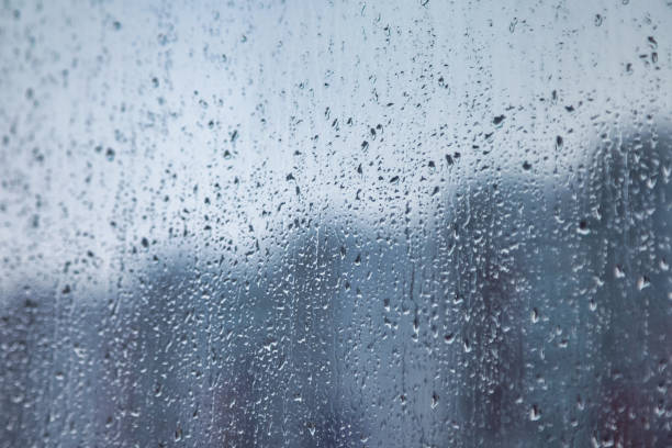 istock Abstract background with rain drops on window and blurred daylight. 1405873756