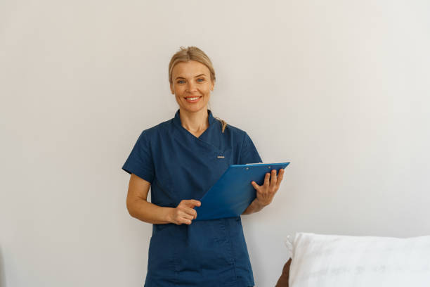 istock Smiling nurse in uniform holding tablet while stands in hospital ward ready to work 1405875324