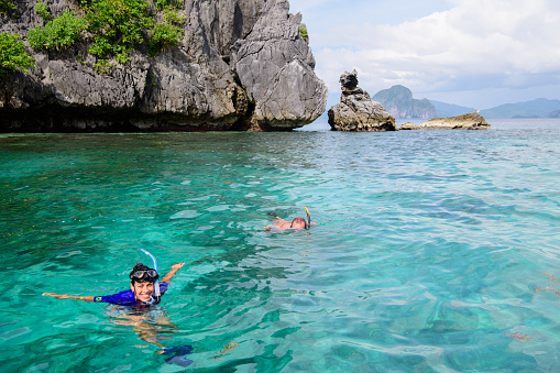 Woman snorkeling and swimming in clear sea water in Asia. Exploring the Natural Sights Around El Nido. Adventure travel.