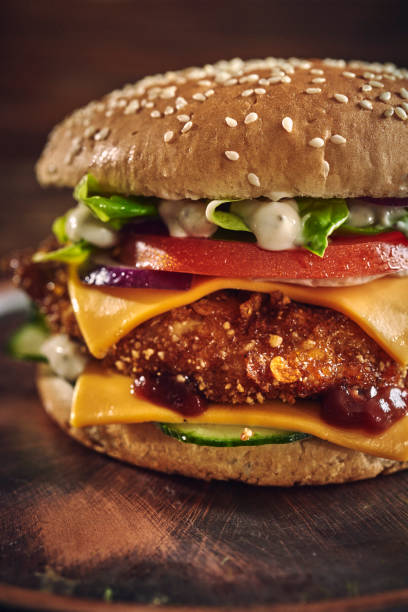 istock Crispy Chicken Burger with Cheese, Tomato, Onions and Green Salad 1405876796
