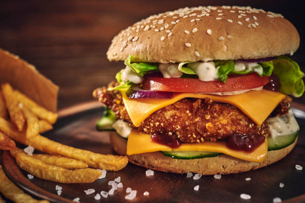 istock Crispy Chicken Burger with Cheese, Tomato, Onions and Green Salad 1405876803