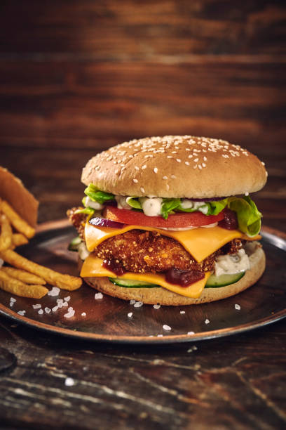 istock Crispy Chicken Burger with Cheese, Tomato, Onions and Green Salad 1405876809