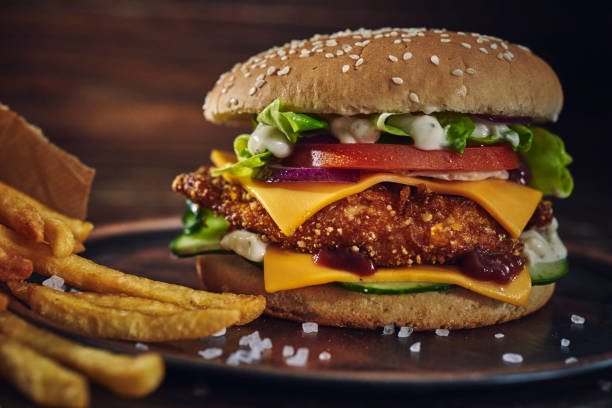 istock Crispy Chicken Burger with Cheese, Tomato, Onions and Green Salad 1405876812