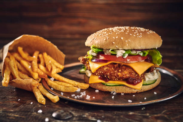 istock Crispy Chicken Burger with Cheese, Tomato, Onions and Green Salad 1405876814