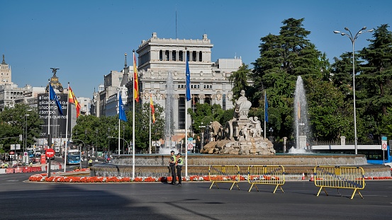Madrid, Spain; 06-29-2022: Flag of Spain and NATO waving together in the Plaza de Cibeles in Madrid on the occasion of the summit organized in the city and police controlling security