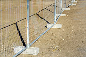 Temporary metallic portable fence with concrete base blocks to limit the territory