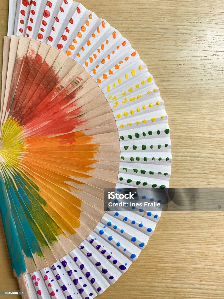 Hand fan painted with the rainbow colors of the LGTBI flag Art Stock Photo