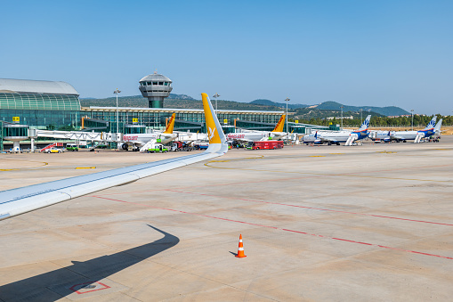 Izmir, Turkey - June 2022: Izmir Adnan Menderes airport departure terminal and runway with aircrafts.  Izmir Airport is one of the busiest airports in Turkey.