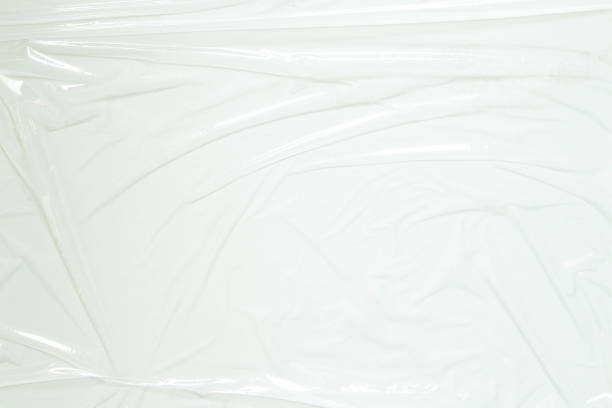 istock Transparent plastic wrap on white color background. Crumpled wrinkled plastic cellophane. Reflecting light and shadow on creases and folds in plastic surface. Texture overlay effect template 1405880517