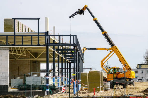 istock Telescopic boom crane and self propelled lift at metal construction frames assemblage 1405880655