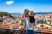 A tourist mother and her little daughter enjoy the view of the beautiful cityscape of Lisbon