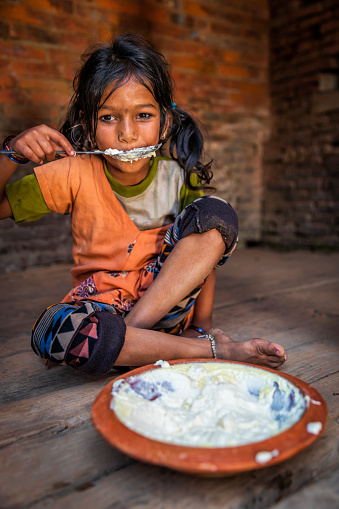 Nepali little girl eating Juju Dhau (which means \