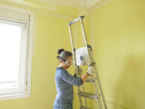 istock Woman painting a yellow wall white 1405883272