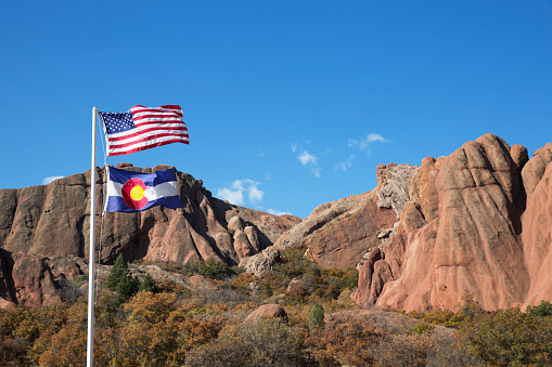 US flag in front of red rock formation at Roxborough State Park in Colorado
