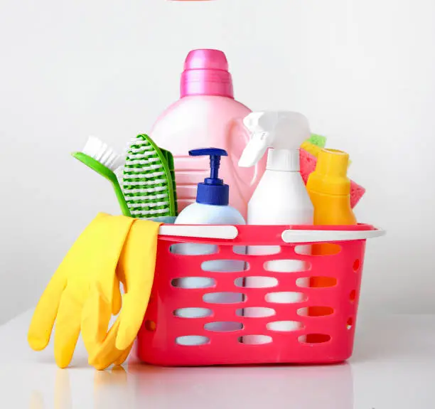 Sanitary,detergent bottles and sponges closeup.Group of household products.Domestic disinfectant. Housekeeping items in basket.