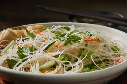 Vietnamese Rice Noodle Salad with Sliced Carrots, Cucumbers, Jalapeno Peppers, Cilantro and a Spring Roll with Ginger Soy Dressing
