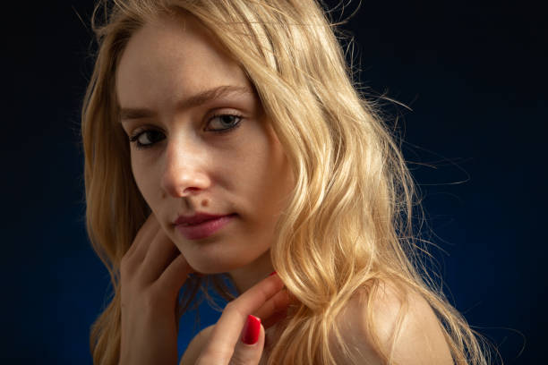 istock sad beautiful blonde transgender with bare shoulders looking at camera 1405889523