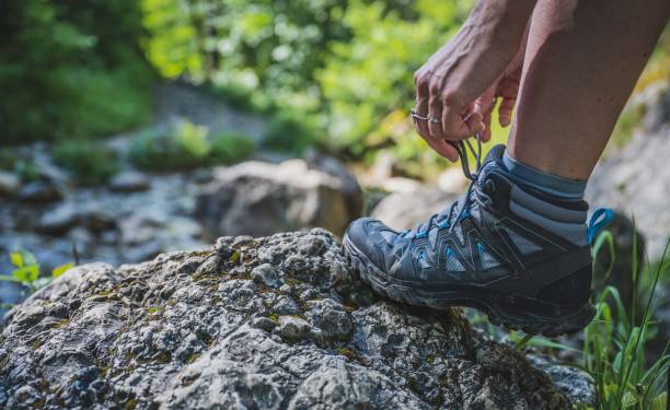istock The traveler ties his shoe on the rock while climbing 1405890468