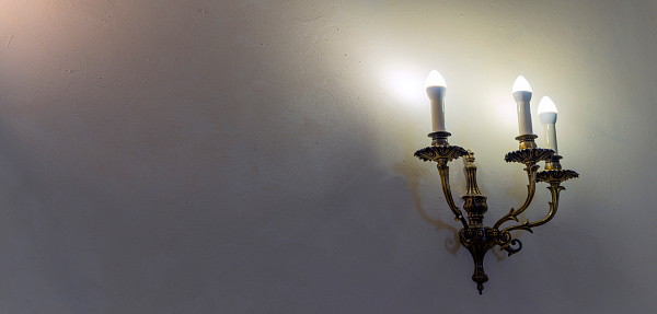 Vintage wall lamp. Space for text. Lamp light on the wall. Working lamps at dusk. Object background.